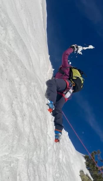 Alpiniste encordé grimpant un mur de neige avec crampons et piolet dans les Pyrénées-Orientales – Bureau des guides Font-Romeu.