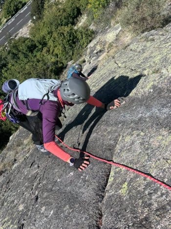 Grimpeur encordé escaladant une grande voie en granit en montagne, neige printanière visible en arrière-plan, stage escalade en Catalogne. Grimpeur encordé escaladant une grande voie en granit en montagne, neige printanière visible en arrière-plan, stage escalade en Catalogne.