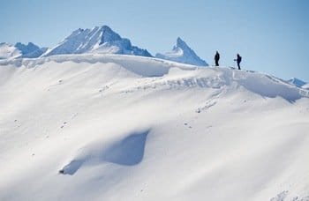 Deux freerideurs sur le point de débuter une descente raide, seuls au monde, dans un vaste paysage enneigé. Deux freerideurs sur le point de débuter une descente raide, seuls au monde, dans un vaste paysage enneigé.