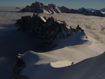 ue du sommet offrant un panorama sur deux autres sommets, avec au loin des alpinistes en pleine ascension. ue du sommet offrant un panorama sur deux autres sommets, avec au loin des alpinistes en pleine ascension.