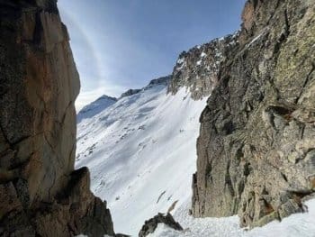 Vue depuis un couloir enneigé encadré par des parois rocheuses, révélant les flancs enneigés de la montagne dans le cœur du Parc Naturel de Posets-Maladeta en Espagne, avec le bureau des guides de Font-Romeu. Vue depuis un couloir enneigé encadré par des parois rocheuses, révélant les flancs enneigés de la montagne dans le cœur du Parc Naturel de Posets-Maladeta en Espagne, avec le bureau des guides de Font-Romeu.