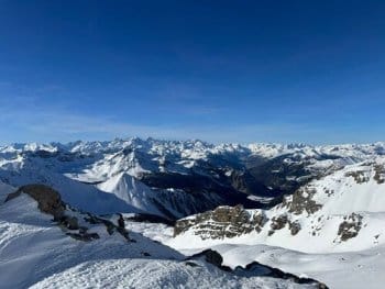 Vue panoramique depuis un sommet offrant une perspective sur de nombreux autres sommets dans le Parc Naturel du Queyras, sous un ciel bleu éclatant, lors d'un raid à ski encadré par un guide de haute montagne de Sensations Pyrénées Vue panoramique depuis un sommet offrant une perspective sur de nombreux autres sommets dans le Parc Naturel du Queyras, sous un ciel bleu éclatant, lors d'un raid à ski encadré par un guide de haute montagne de Sensations Pyrénées