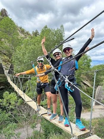 Trois amis joyeux traversant une passerelle de la via ferrata de Llo, Pyrénées-Orientales Trois amis joyeux traversant une passerelle de la via ferrata de Llo, Pyrénées-Orientales